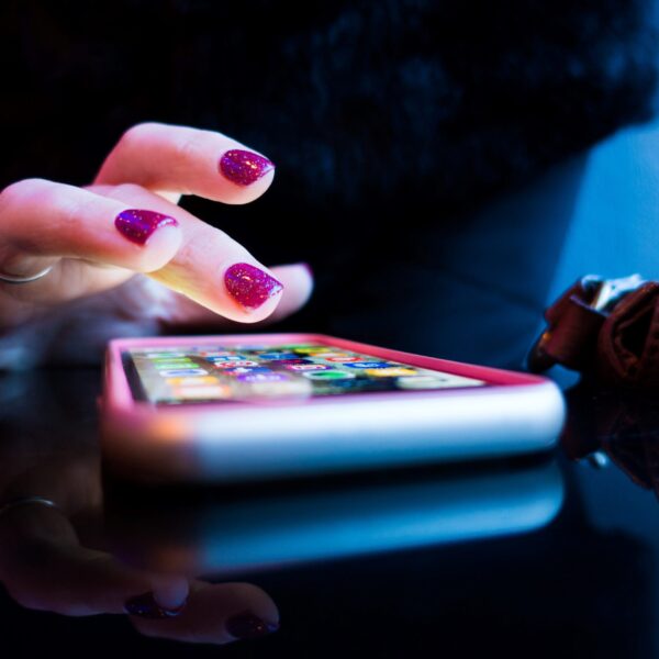 person using black smartphone with gray and pink case