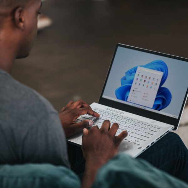 man in gray long sleeve shirt using Windows 11 computer