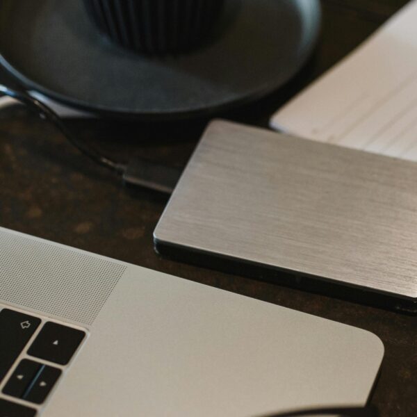 Free Closeup of an external hard drive connected to a laptop with a USB cable on a desk. Stock Photo